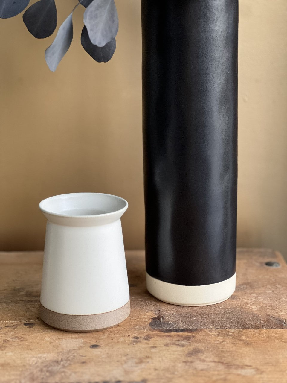 Black ceramic vase with cream band base